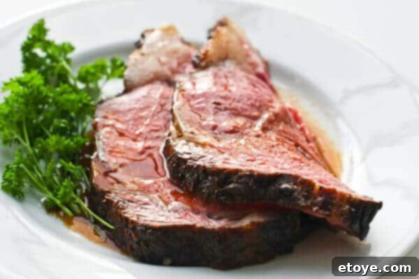 Slices of perfectly cooked prime rib with a beautiful pink center, ready to be served.