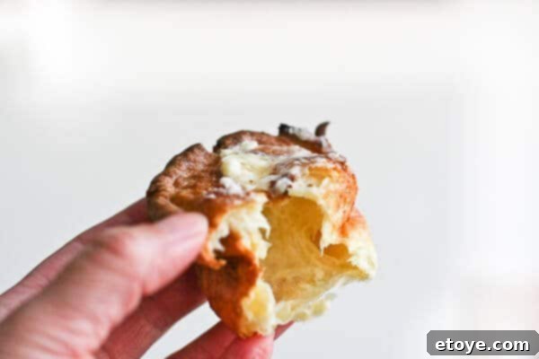 A freshly baked Yorkshire Pudding with a bite taken out, revealing its airy interior.