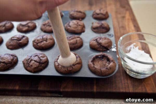 Brushing coffee liqueur generously onto the indented cupcakes