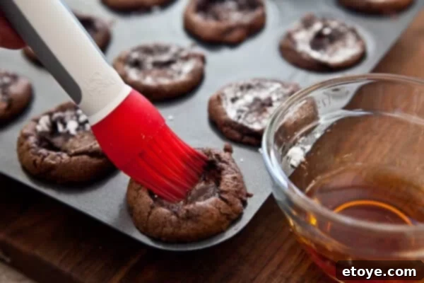 Piping mascarpone filling into the cupcake indentations