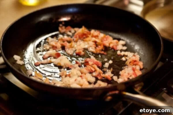 Crispy Bacon and Sweet Peas 9 A bag of frozen peas being poured into a pan with cooked bacon and onions.