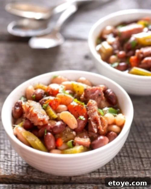 New Year Good Luck Black Eyed Peas and Ham 6 black eyed peas with ham in white bowl on table with spoon.