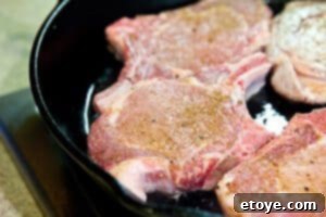Pork chops searing in a hot skillet for a golden crust