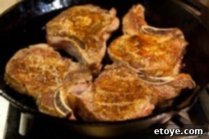 Removing seared pork chops from the pan