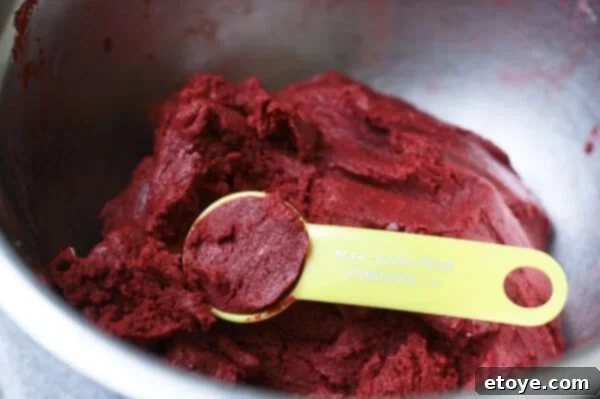 Scooping and rolling red velvet cake mixture into balls