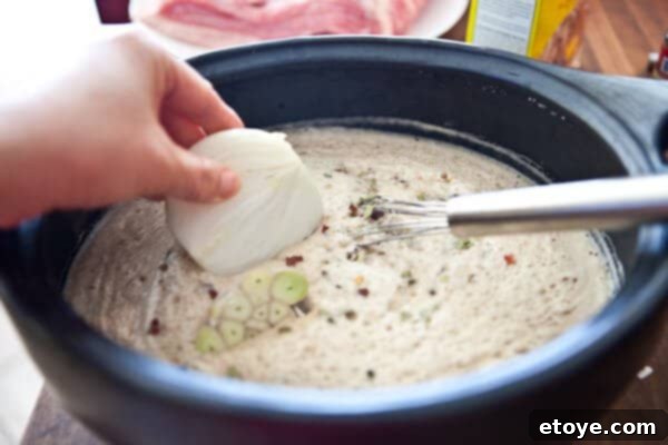 The Ultimate Guinness Corned Beef and Cabbage 8 placing onion in pot