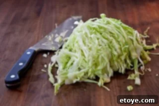 Hearty White Bean and Cabbage Stew 5 Finely shredded green cabbage in a bowl, ready for cooking.