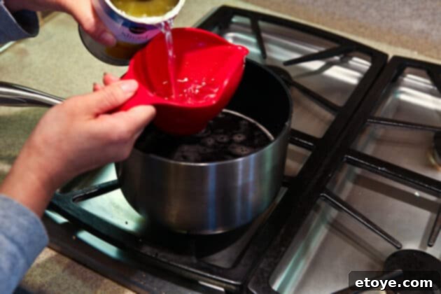 Sweet and Savory Cola Pineapple Glazed Ham 11 Adding pineapple juice to the glaze mixture in the saucepan.