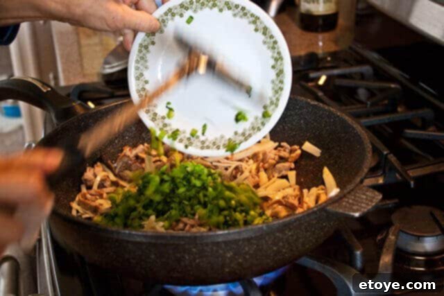 Savory Nian Gao Stir-Fry 11 All ingredients in the wok being tossed vigorously to combine flavors.