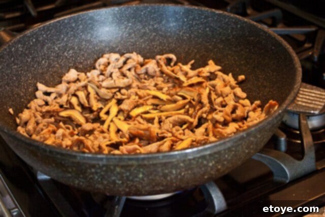 Savory Nian Gao Stir-Fry 9 Bamboo shoots being added to the wok with pork and mushrooms.