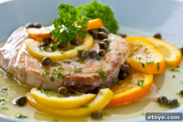 How to Cook Fish with Citrus Caper Sauce Cooking pan with pan-seared fish and citrus slices