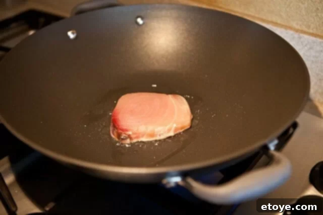 Searing Fish in a Wok Fish fillet searing in a hot skillet with olive oil