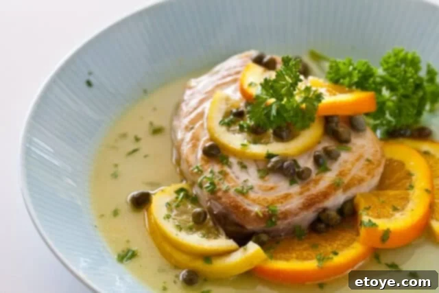 Plated Fish with Citrus Caper Sauce Close-up of a perfectly cooked fish fillet with citrus caper sauce, served on a white plate