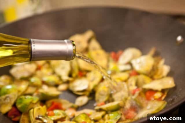 Adding white wine and vegetable broth to the pan.