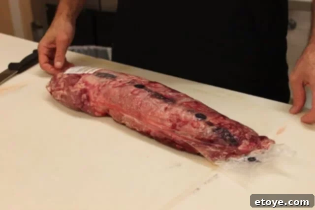 Draining excess liquid from a beef tenderloin package before unwrapping