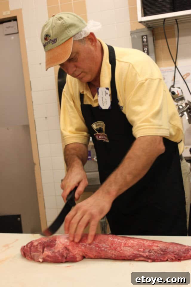 Close-up view of a freshly cut filet mignon steak showing fat and silver skin