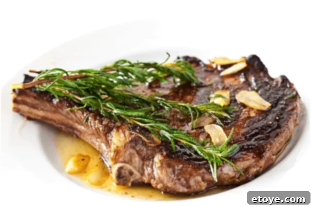 Perfectly seared rosemary garlic steak resting on a cutting board, ready to be sliced.