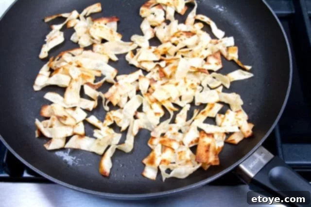 Crispy Golden Wontons Finished crispy golden-brown wonton strips in a frying pan