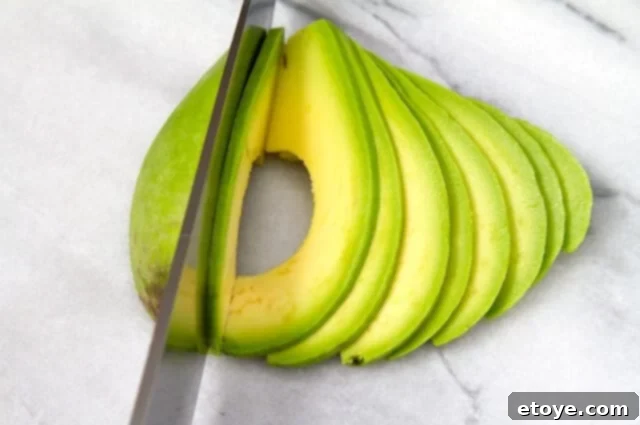 Slicing Avocados for Salad Hands slicing a fresh avocado, preparing it for a vibrant salad