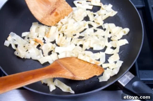 Tossing Wontons Wonton strips being tossed in a frying pan, starting to turn golden