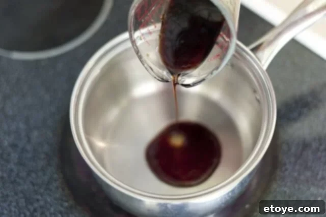 cooking steak_2 Pouring soy sauce into a saucepan over low heat.