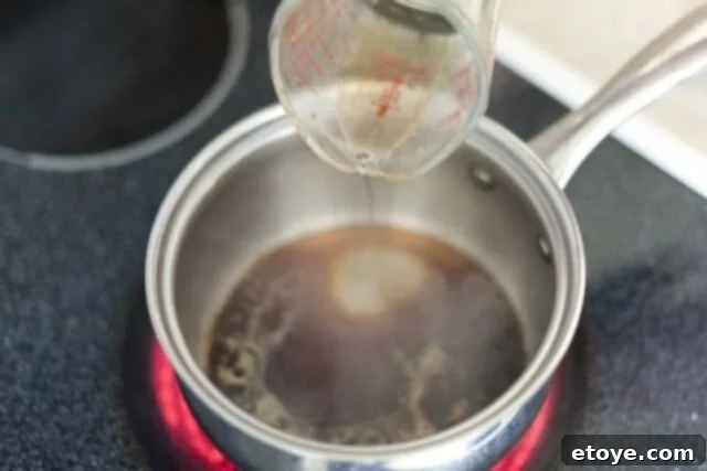 cooking steak_3 Adding mirin, Japanese sweet rice wine, to the soy sauce in a saucepan.