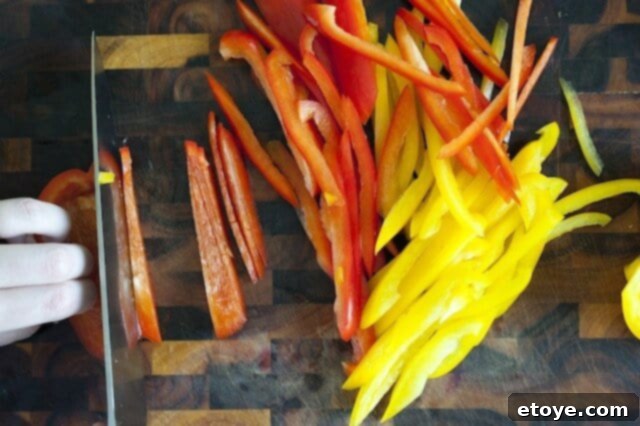preparing steak_1 Slicing bell peppers into thin strips on a cutting board.