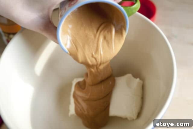 Peanut Butter Pie Blending Base Peanut butter and cream cheese are being blended with a hand mixer in a bowl.