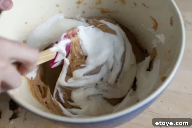 Peanut Butter Pie Folding Whipped Cream The remaining whipped cream is gently folded into the peanut butter pie filling for a light texture.