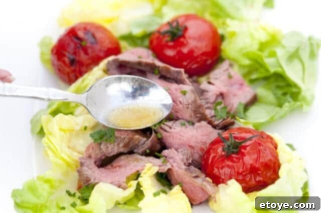 Slicing a perfectly grilled flank steak against the grain to ensure maximum tenderness for the salad