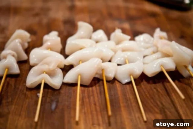 Calamari pieces threaded onto bamboo skewers