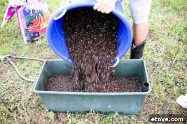 Smart Gardening with Earthboxes 11 Pouring the remaining wet potting mix into the EarthBox container