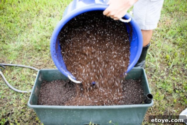 Smart Gardening with Earthboxes 16 Adding the first third of the dry potting mix to the EarthBox