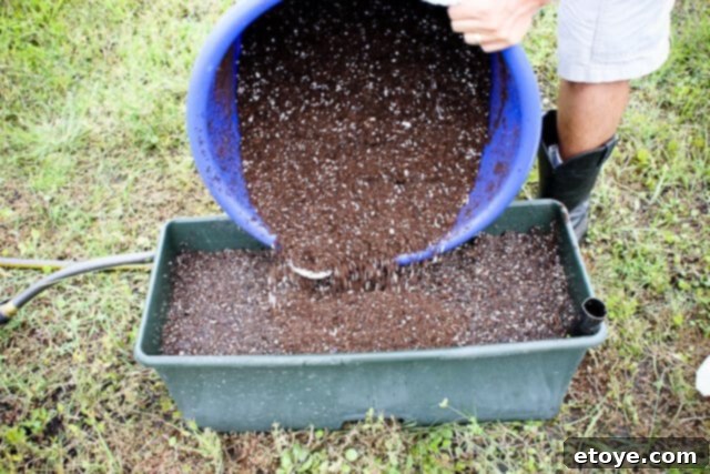 Smart Gardening with Earthboxes 18 Adding the second third of the dry potting mix to continue layering