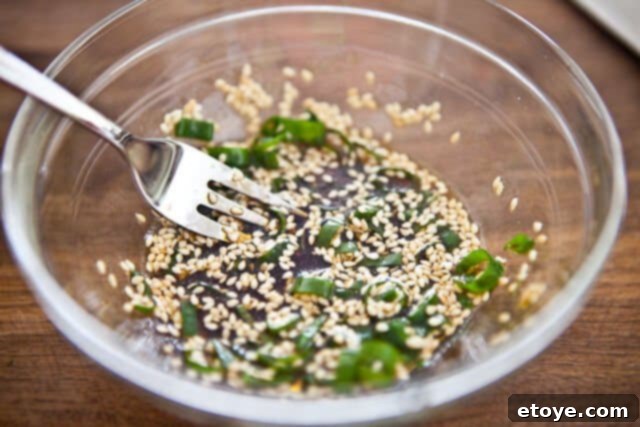 Close-up of Sesame Ponzu Vinaigrette being whisked in a bowl.