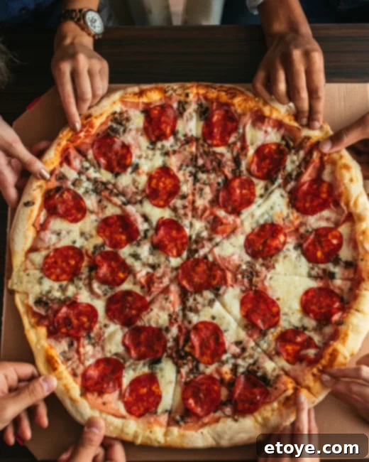 Win a Stovetop Pizza Oven 7 Person taking a pizza out of the BakerStone oven