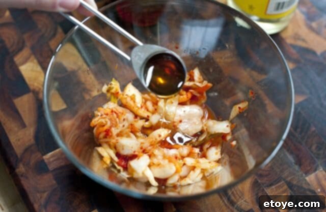Making Kimchi Relish Mixing kimchi, honey, and rice vinegar in a bowl to make kimchi relish