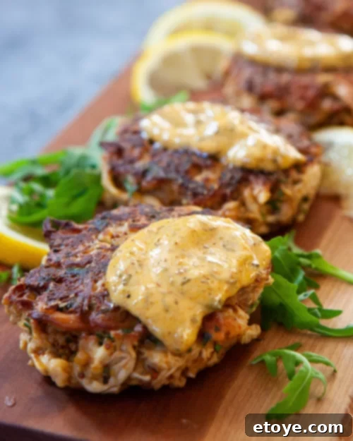 Golden brown Lion's Mane Crab Cakes served with lemon wedges and sauce