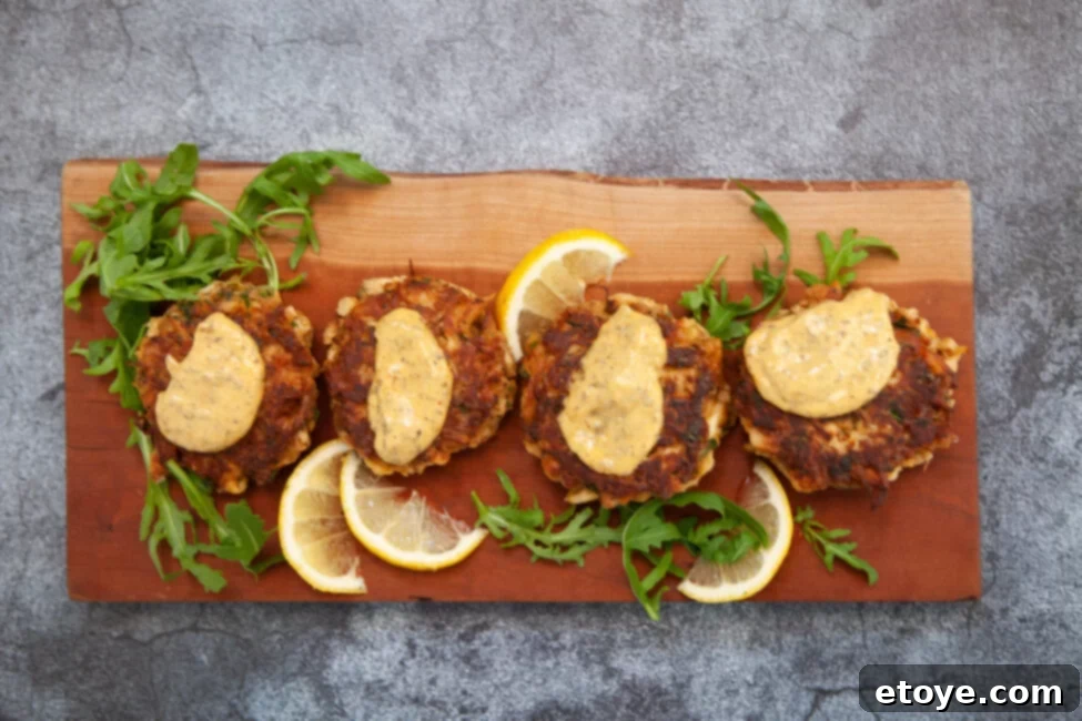 Lion's Mane Crab Cakes arranged on a platter with remoulade sauce, fresh herbs, and lemon wedges