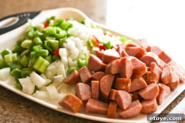 Gumbo ingredients simmering gently in a large pot, the broth bubbling with aromatic vegetables and sausage.