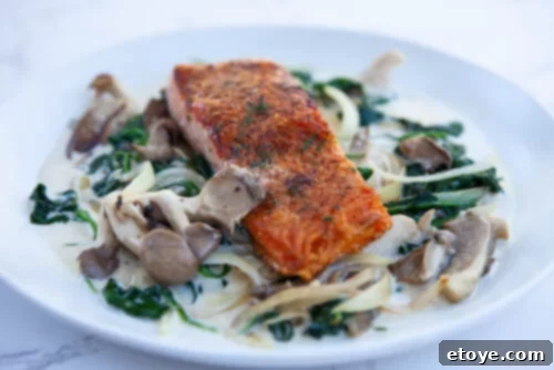 Pan-Seared Salmon with Creamy Spinach and Mushroom Sauce 2 Pan-seared salmon with creamy spinach and mushroom sauce, garnished with fresh herbs, perfect for a mood-boosting meal.