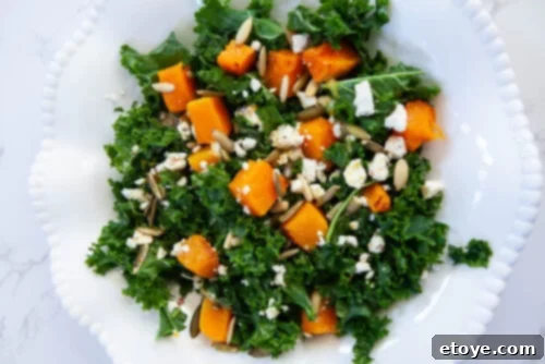 A vibrant close-up view of the prepared Roasted Squash, Kale & Feta Salad, showcasing its inviting textures, rich colors, and delicious dressing, ready to be enjoyed as a mood-boosting meal.
