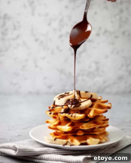 Waffles with Bananas, Chocolate Drizzle, and Powdered Sugar