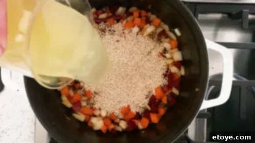 Wholesome Honey Mustard Chicken with Golden Quinoa Pilaf 7 Adding chicken broth and quinoa to the sautéed vegetables