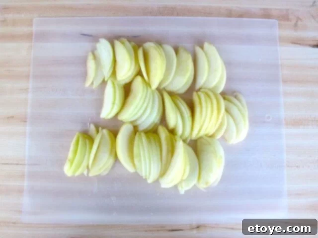 Apple Cinnamon Filling Preparation Sliced apples mingling with brown sugar, vanilla, and cinnamon in a bowl