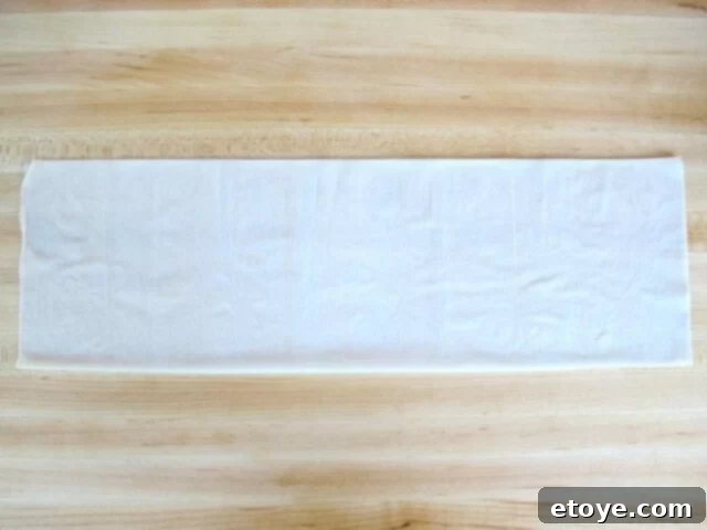 Preparing Filo Dough Strips Long strip of double-layered filo dough on a work surface