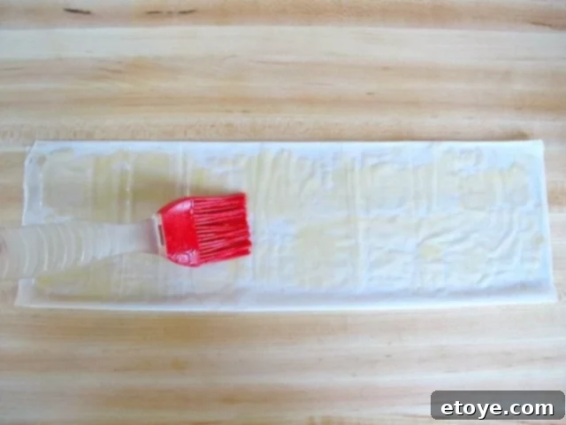 Butter Your Filo Brushing melted butter onto a filo dough strip with a pastry brush
