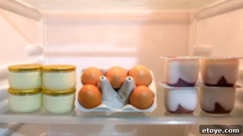 Milk, butter, cream cheese, eggs, and yogurt stored on the middle shelf