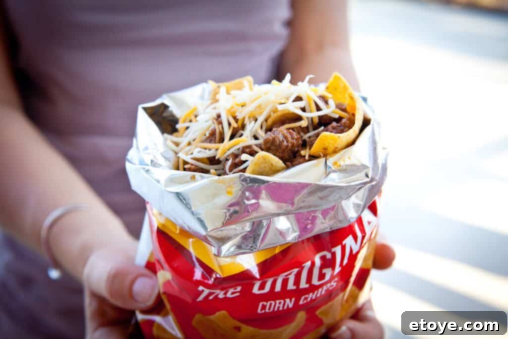 Frito Pie Recipe hand holding frito pie in bag
