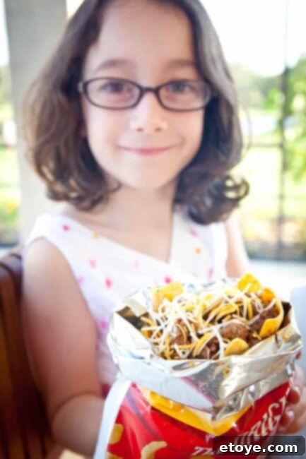 Frito Pie Recipe kid holding bag of frito pie